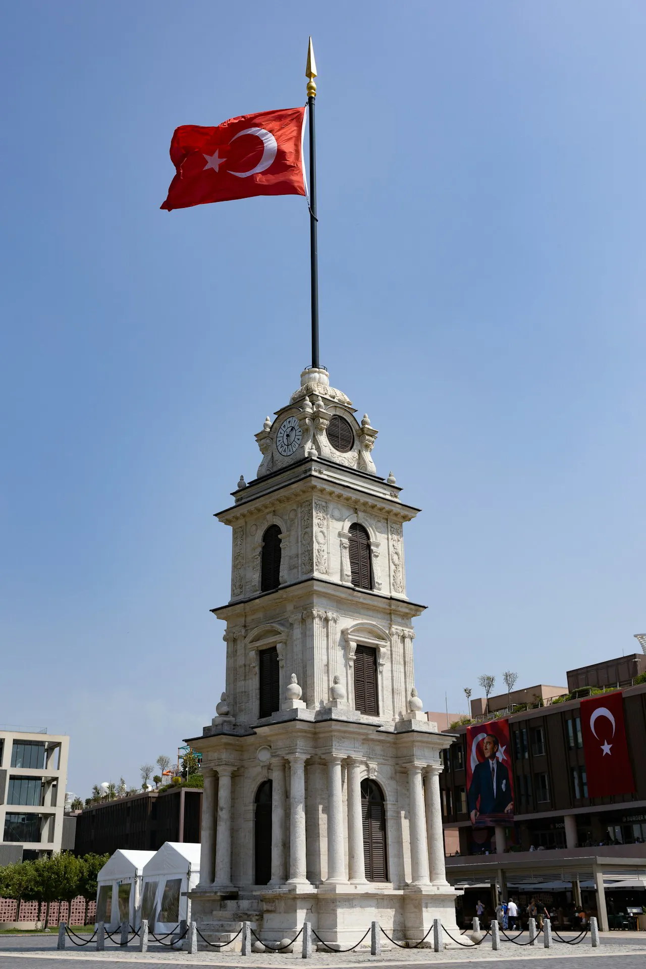Türkiye bayrağı kentsel bir saat kulesinin önünde dalgalanıyor — 12 Mayıs 2026 World Farmers' Day çerçevesinde 'dengeli dış politika sayesinde gıda tedarik zinciri korundu' iddiasının cross-check argümanına sembolik gönderme
