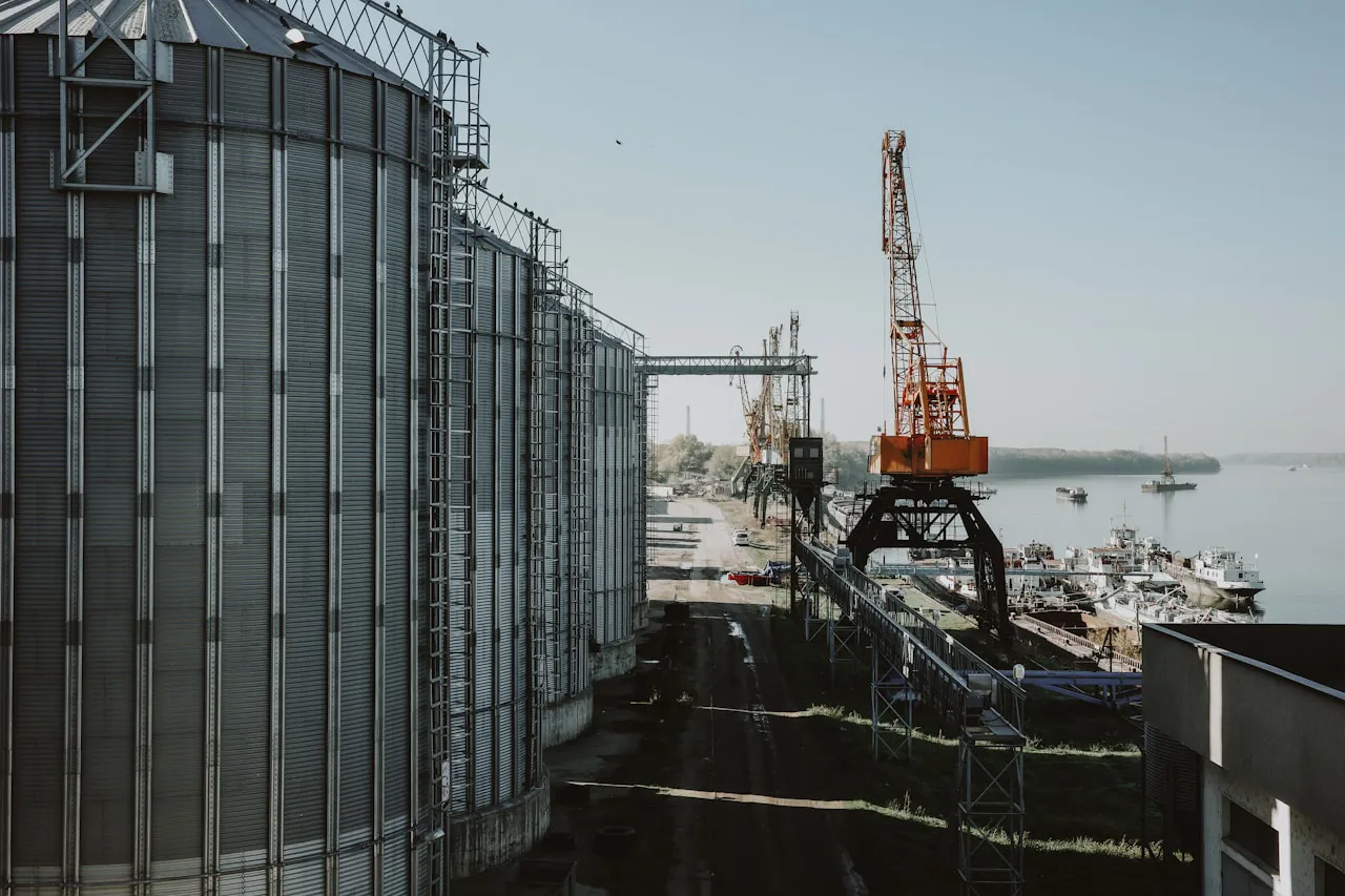 Karadeniz tarzı tahıl limanı, yükleme rıhtımında endüstriyel silolar ve yükleme vinçleri — Karadeniz tahıl koridorunun Türkiye'nin Hürmüz şokunda neden alternatif değil, paralel sigorta hattı olduğuna gönderme
