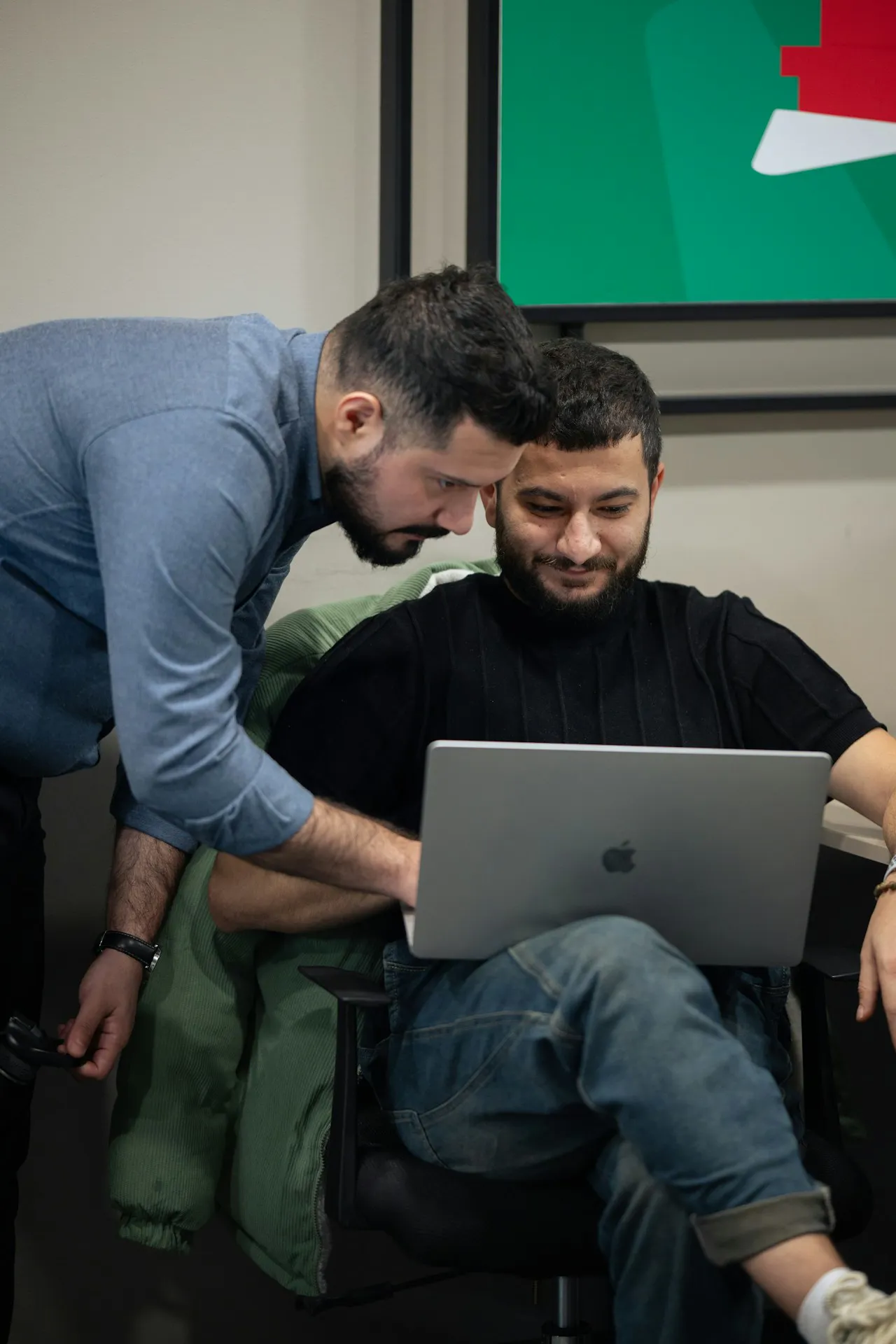 İki yazılım mühendisi laptop önünde kod gözden geçiriyor